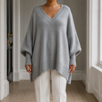 Grey V neck jumper shown from the front with its wide batwing shape and ribbed hem visible.